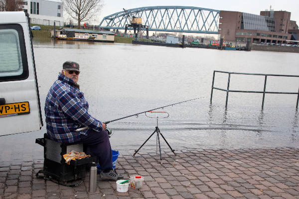 \"Nijmegen, 13-12-2010 .  Water Waal stijgt, visser moet elk kwartier opschuiven\"