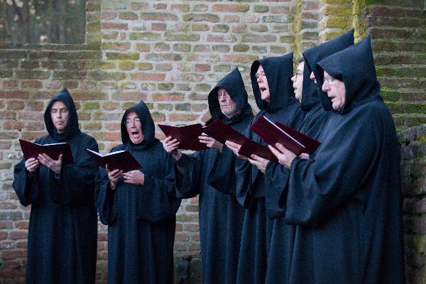 \"Overasselt: Processie en Gregoriaanse gezang van de Schola Cantorum Karolus Magnus bij de koortsboom in Sint Walrick. Bij het ochtendgloren klonk de Hymnus ad Galli cantum: de hymne bij het kraaien van de haan.\"
