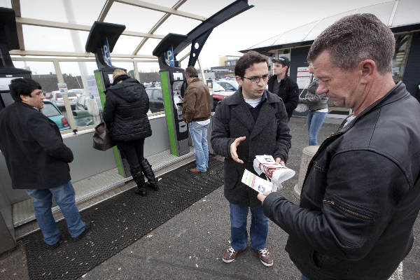 \"Nijmegen, 4-3-2012 . Jongens en meiden geven uitleg over het telefoonparkeren, gsm, sms parkeren in Nijmegen. Parkeerautomaat,  dak Molenpoortpassage\"