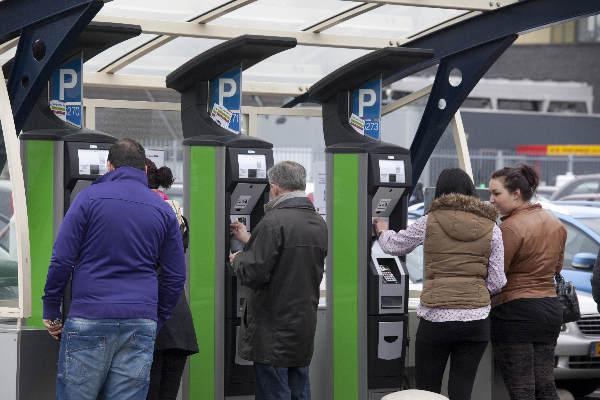 \"Nijmegen, 4-3-2012 . Parkeerautomaat met rij mensen op dak Molenpoortpassage\"