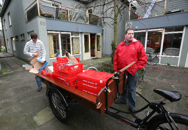 \"TU Twente, op de campus studenten en Andre, de papierophaler\"