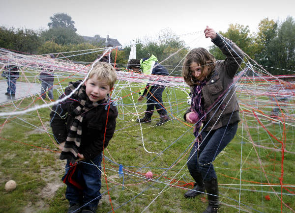 \"opening speelveld Slijk Ewijk, Op de hoek Paulstraat/Loenensestraat Kinderen hebben spinneweb geweven\"