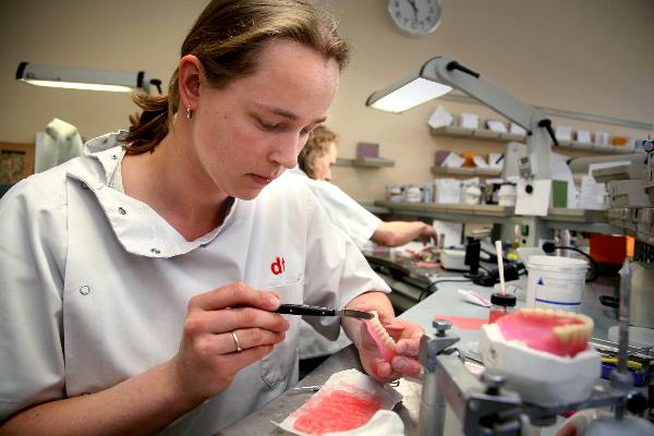 \"assistent tandtechnicus Afbeelding van een meisje dat druk bezig is een kunstgebit te maken. In witte jas.\"