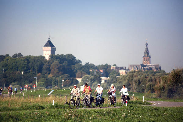 \"Fietsers op de banddijk met op de achtergrond de Donion en de Stevenskerk, Mooi weer!\"