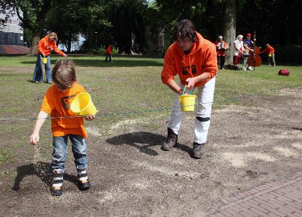 \"Met muziek zaait bestuur Valkhofaffire en Dag vhLevenslied het Valkhofpark met nieuw graszaad in.\"