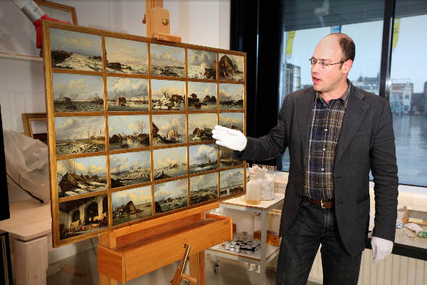 \"Conservator Ruud Priem, Valkhof museum met schilderij van de Watersnood in 1850 in soort stripvorm\"