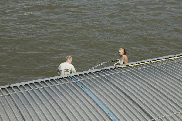 \"schoonmaken vrachtschip, tuinslang, mooi weer\"