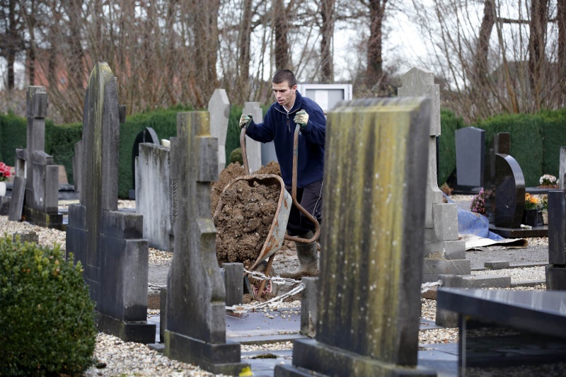 Werner Weijkamp van het Gelders Genootschap voert voor de gemeente Wijchen een inventarisatie uit van begraafplaatsen.  op de begraafplaats staat ook nog een 'knekelhuisje'.  Adriaan Strik (85) loopt ook mee.. Batenburg, 11-12-2014 . dgfoto.