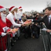 \"J.P Balkenende neemt een koekje aan van aktievoerders bij de onthulling van de godenpijler in Nijmegen\"