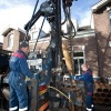 \"Slaan, boren van put in de Claas Noorduynstraat. In opdracht van de gemeente worden Nijmegen oost meerdere putten geslagen met meet apparatuur voor het rondwater. Deze put gaat 50 meter diep.Op deze plek zit het grondwater op 30 meter.\"